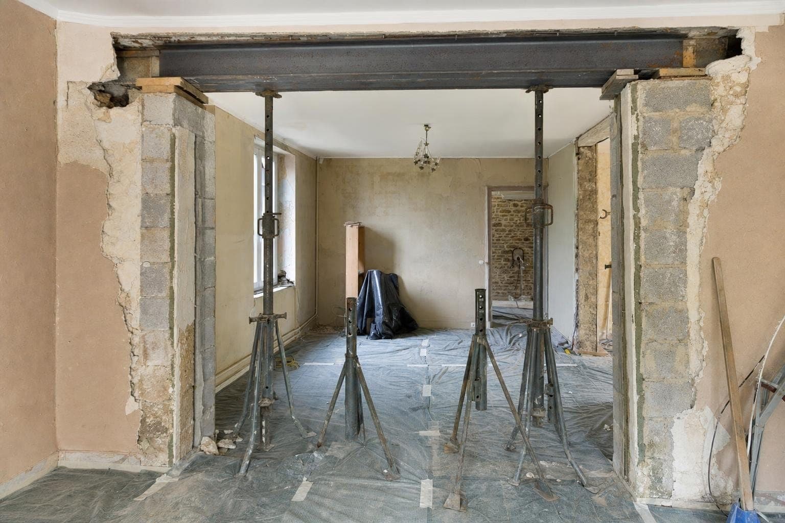 Grande ouverture dans un mur porteur avec poutre IPN posée sur appuis et étais métalliques
